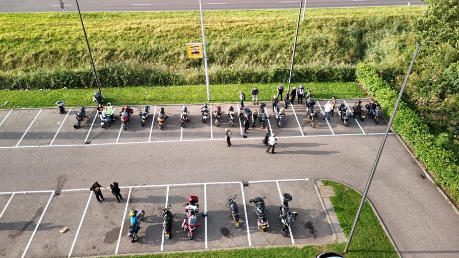 Verzamelpunt Mac Donalds in Spijkenisse Een luchtfoto van een parkeerplaats met mensen die in een rij staan.